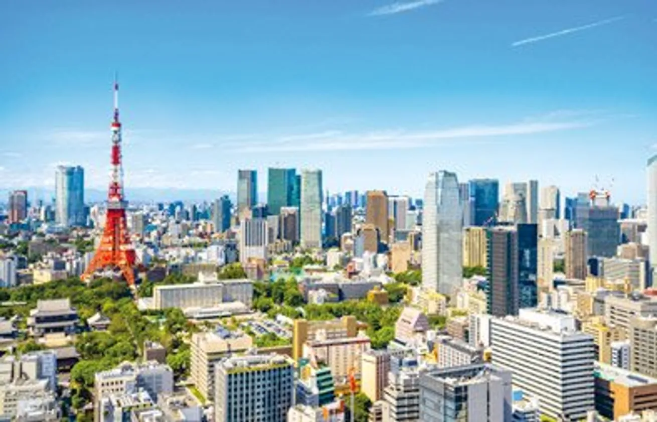 Aerial view of Tokyo with the Tokyo Tower in the foreground and modern skyscrapers in the background.